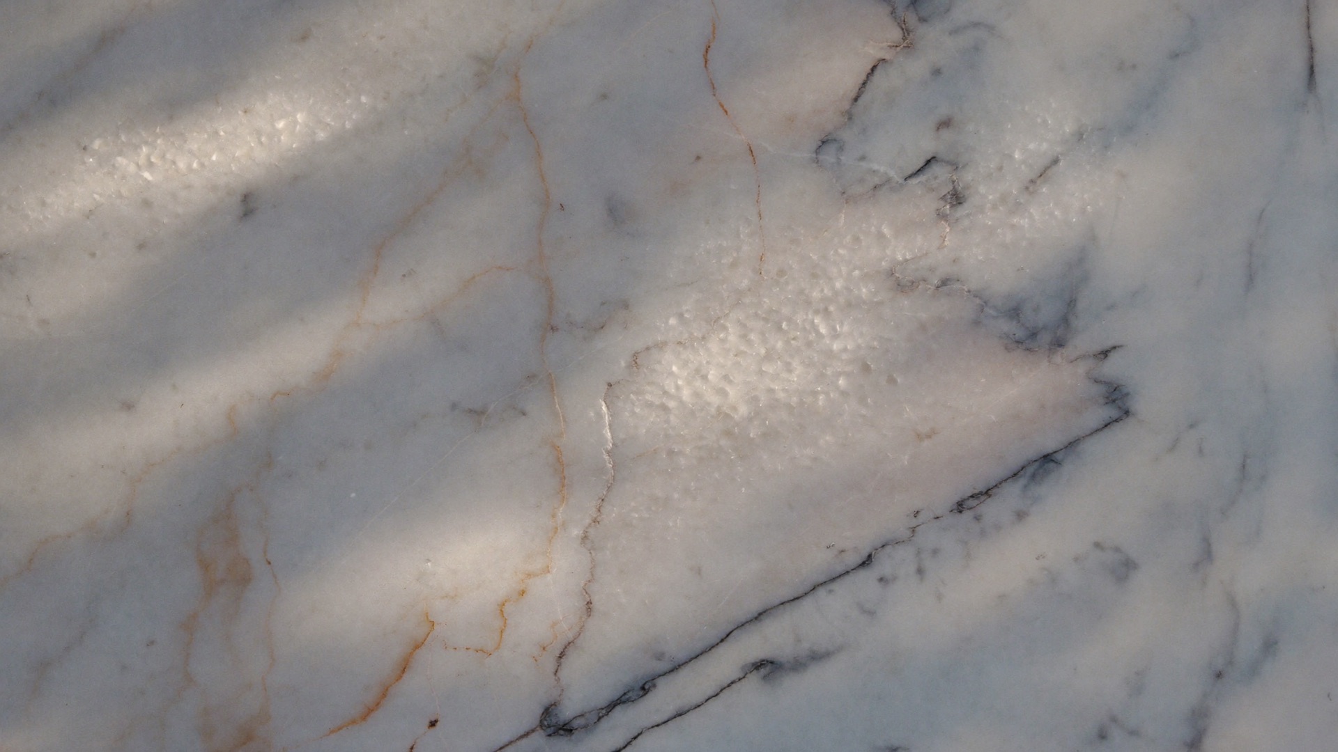 Macro of honed marble veining catching side light — the material at the heart of a Scottsdale remodel budget